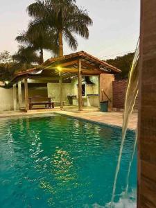 a swimming pool in front of a house at @ Chácara 5 Anjos - Jacuzzi Incrível Água Quente in Itanhaém