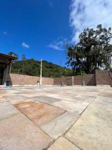 an empty parking lot with a tree in the background at @ Chácara 5 Anjos - Jacuzzi Incrível Água Quente in Itanhaém