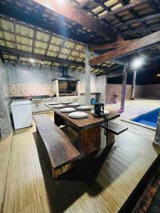 a large kitchen with a table and a stove at @ Chácara 5 Anjos - Jacuzzi Incrível Água Quente in Itanhaém