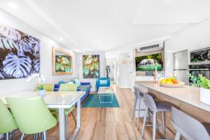 een keuken en een woonkamer met een tafel en stoelen bij Wantima Hastings St 1 Bedroom Unit in Noosa Heads