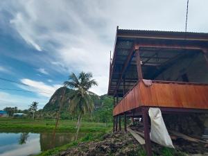 a building with a palm tree next to a body of water at RAMMANG-RAMMANG HOUSE in Maros