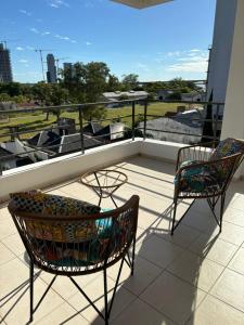 2 sedie e un tavolo sul balcone con barca di Departamento Il Piamonte a Corrientes