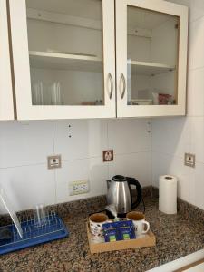 a kitchen counter with a cupboard and a tea kettle at Departamento Il Piamonte in Corrientes