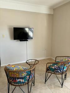 una camera con due sedie e una TV a parete di Departamento Il Piamonte a Corrientes