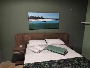 a bed with white sheets and a green pillow on it at Casa de Praia Paraíso Paracuru Ceará in Paracuru +111 photos