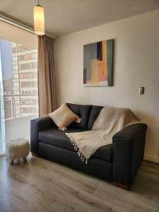 a black couch in a living room with a window at Acogedor Apartamento en Centro de Santiago. in Santiago