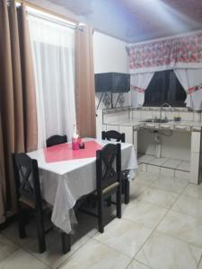 cocina con mesa, sillas y fregadero en Villa1 Coral Carrillo, en Arbolito