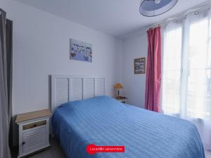 a bedroom with a blue bed and a window at Maison Châtelaillon-Plage, 3 pièces, 4 personnes - FR-1-535-27 in Châtelaillon-Plage
