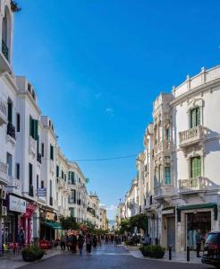 une rue de la ville avec des bâtiments et des personnes marchant dans une rue dans l'établissement Flat In Tetouan City Centre Medina - NEW Dar Azhar, à Tetouan