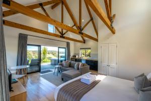 The Guest House at Te Whau Retreat في Omiha: غرفة نوم مع سرير وغرفة معيشة
