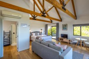 OmihaにあるThe Guest House at Te Whau Retreatのリビングルーム(ベッド1台、ソファ付)