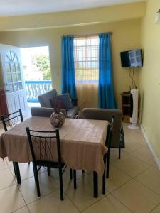 a dining room table with chairs and a living room at SK S Haven #1 in Castries