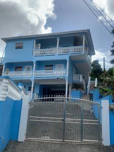 a blue house with a fence in front of it at SK S Haven #1 in Castries