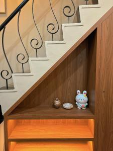 un armario de madera bajo las escaleras con un juguete. en Ran has to get up en Tainan