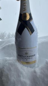 a bottle of champagne sitting in the snow at Hocheckhuette On Top of the Kitzbuehel Hahnenkamm Mountain in Kitzbühel