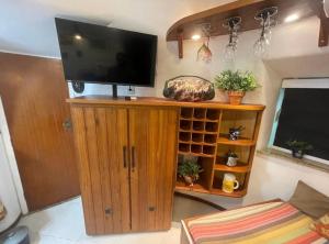 uma sala de estar com uma televisão de ecrã plano num armário de madeira em Cabana Bela Vista em Búzios