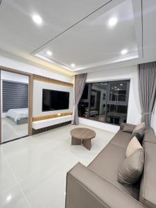 ニャチャンにあるBeachfront House Nha Trangのソファとテレビのあるリビングルーム +16枚の写真
