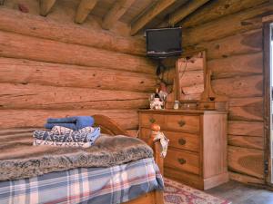a bedroom with a bed and a tv in a log cabin at 1 Bed in Latchley 54164 in Sydenham Damerel