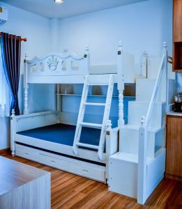 a white bunk bed with a ladder in a room at Nainan resotel ในน่าน รีโซเทล in Nan