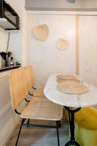 een witte tafel en 2 stoelen in een keuken bij La Suite privée des Chevaliers in Parijs