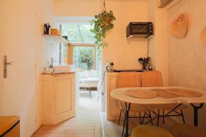 a kitchen with a table and a dining room at La Suite privée des Chevaliers in Paris