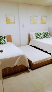 two beds in a room with white walls at Apartamentos Aury in San Andrés