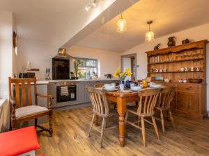 a kitchen with a wooden table and chairs at 3 Bed in Widemouth Bay 77815 in Marhamchurch