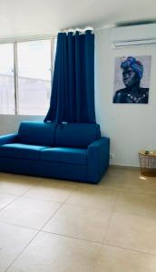 a blue couch in a room with a blue curtain at Little urban idéal pour les séjours de moyenne durée proche de tout in Pointe-à-Pitre