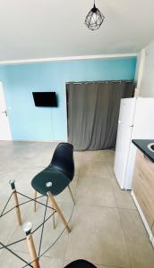 una silla negra en una habitación con TV en Little urban idéal pour les séjours de moyenne durée proche de tout en Pointe-à-Pitre