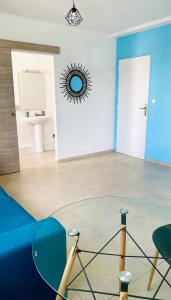 een woonkamer met een blauwe bank en een spiegel bij Little urban idéal pour les séjours de moyenne durée proche de tout in Pointe-à-Pitre