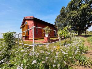 een klein huis in een veld met bloemen bij Girija Homestay in Shamsgarh