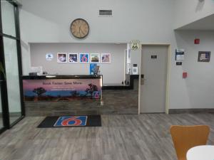 een lobby met een klok aan de muur en een wachtkamer bij Motel 6-Winslow, AZ in Winslow