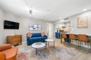 ein Wohnzimmer mit einem blauen Sofa und einem Tisch in der Unterkunft Chic Condo Retreat in Central Buckhead Atlanta in Atlanta