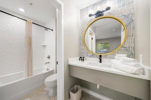 ein Badezimmer mit einem Waschbecken, einem Spiegel und einem WC in der Unterkunft Chic Condo Retreat in Central Buckhead Atlanta in Atlanta