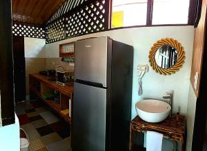 a kitchen with a refrigerator and a bowl on a counter at Cabaña que Tuanis in Fortuna