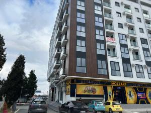 a tall building with cars parked in front of it at De Lux Nedeljkovic President in Jagodina