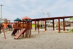 un parque con parque infantil con estructura de madera en Acogedora casa en Pisco a 20 min de paracas, en Pisco