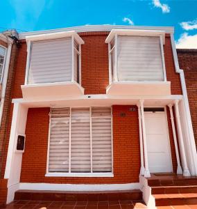 a red brick house with two white windows at CASA PRIVADA EN BOGOTA in Bogotá