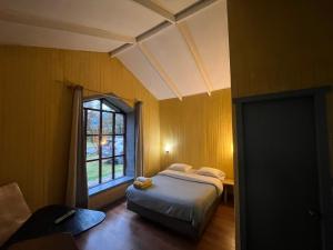 a bedroom with a bed and a window at QUELEN AUSTRAL in Hornopiren