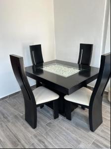 a black table with two chairs and a black table at Departamento Amueblado con Alberca Pedregal C in Tamasopo