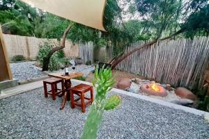 a garden with a table and chairs and a fire pit at Borde rio, Eco-Cabaña Jararankhu in Vicuña