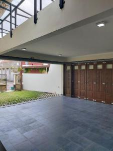un garage avec des portes en bois et une cour dans l'établissement Guesthouse Syariah Griya Truntum, à Lawean