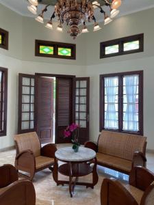 sala de estar con sofás, mesa y ventanas en Guesthouse Syariah Griya Truntum en Lawean