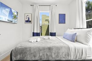 a bedroom with a bed with two towels on it at Palm Wave Says - Designers Stay - No Extra Fees in West Palm Beach