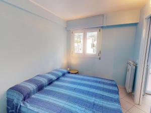 ein blaues Bett in einem Zimmer mit Fenster in der Unterkunft Studio Menton, 2 pièces, 4 personnes - FR-1-196-348 in Menton