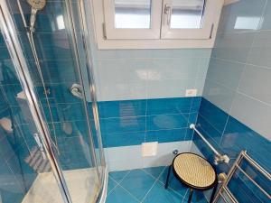 ein blau gefliestes Bad mit einer Dusche und einem Stuhl in der Unterkunft Studio Menton, 2 pièces, 4 personnes - FR-1-196-348 in Menton