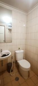 Convenient Apartments at West Jakarta في جاكرتا: حمام مع مرحاض ومغسلة