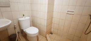 a small bathroom with a toilet and a sink at Convenient Apartments at West Jakarta in Jakarta