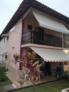 a house with a balcony and a yard at Flat Gorlaes in Araruama