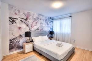 una camera da letto con un grande murale floreale sul muro di Style & Comforts by Montreal - New - 3BR Bungalow a Candiac